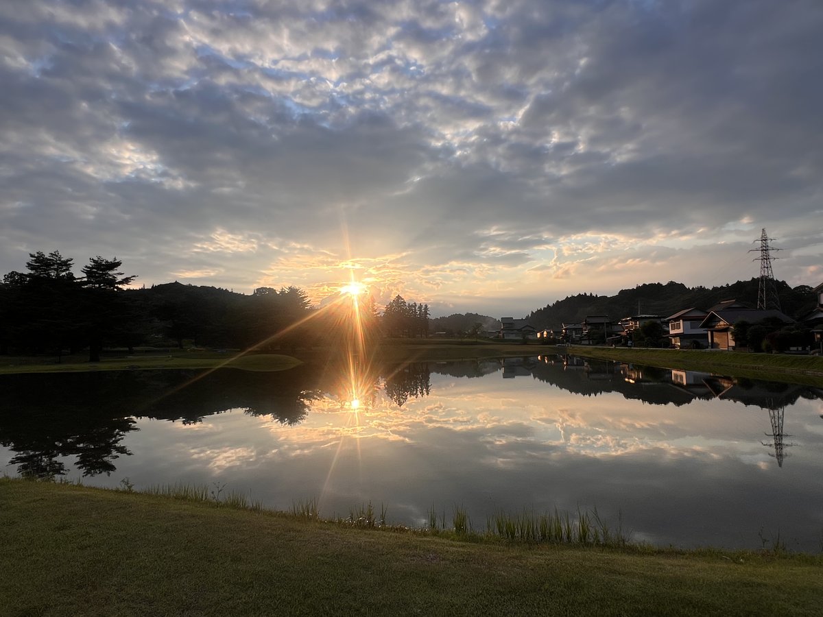 Sunset over Hiraizumi Muryokoin with calm fields and traditional homes